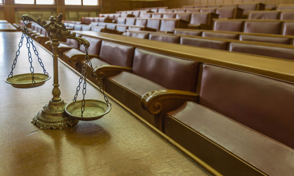 Symbol of law and justice in the empty courtroom, law and justice concept, focus on the scales